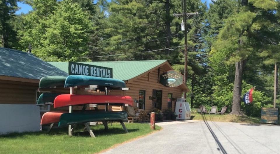 A log structure with a rack for canoes out front.