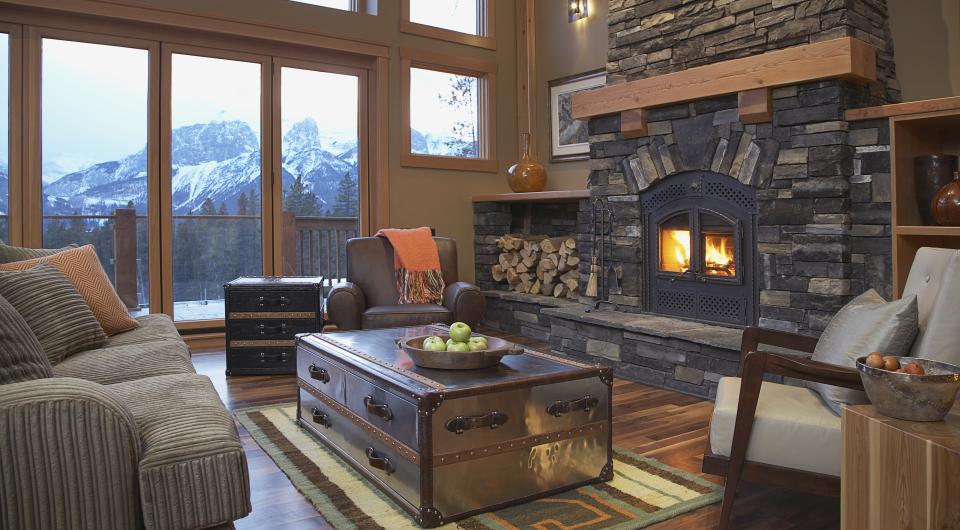 A grand living room with stone hearth and mountain views