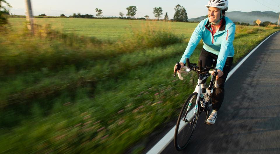 A woman cycling in the Lake Champlain Region.