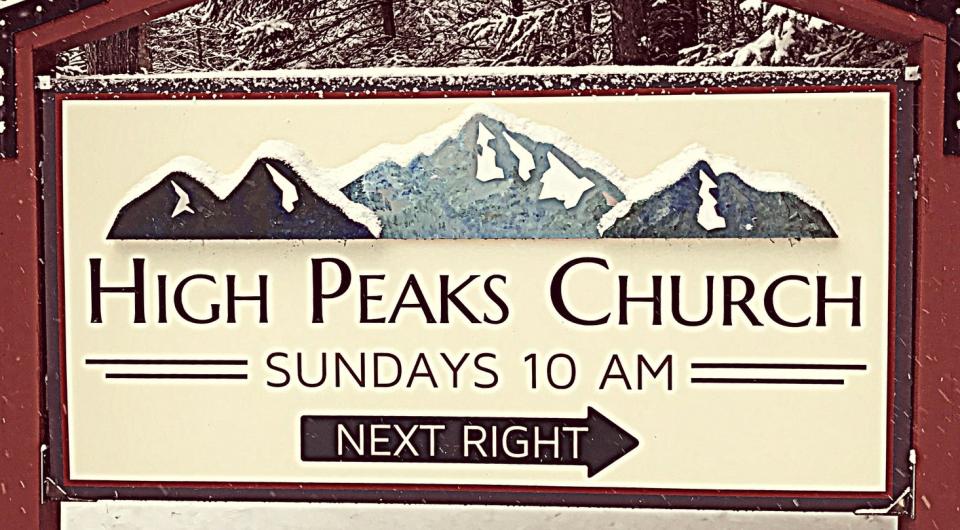 A sign for the entry to High Peaks Church blanketed in light snow