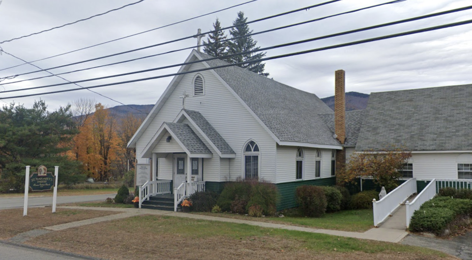 Roadside view of the quaint white church entrance.
