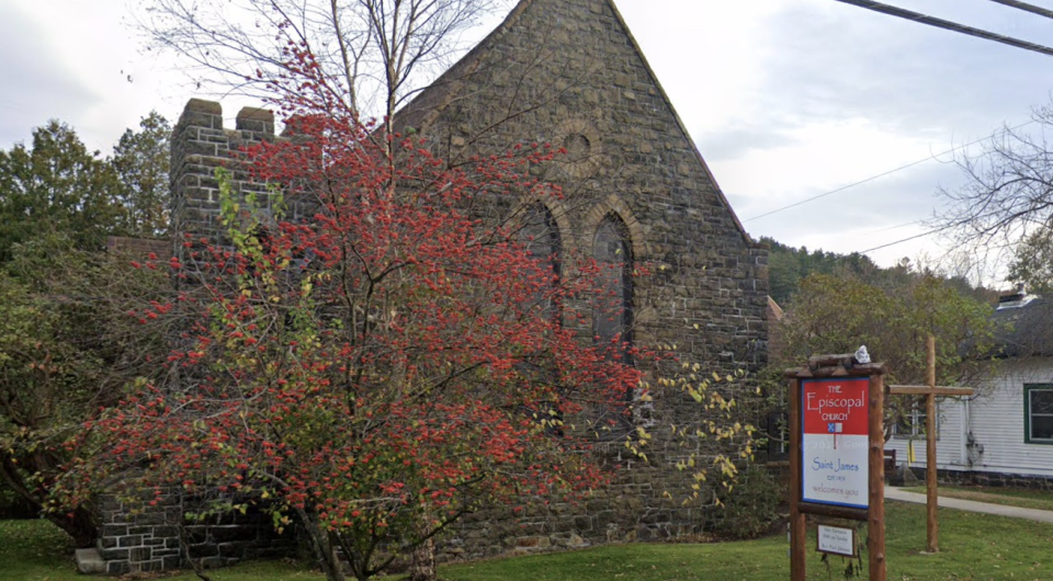 An old stone church with a flowering tree