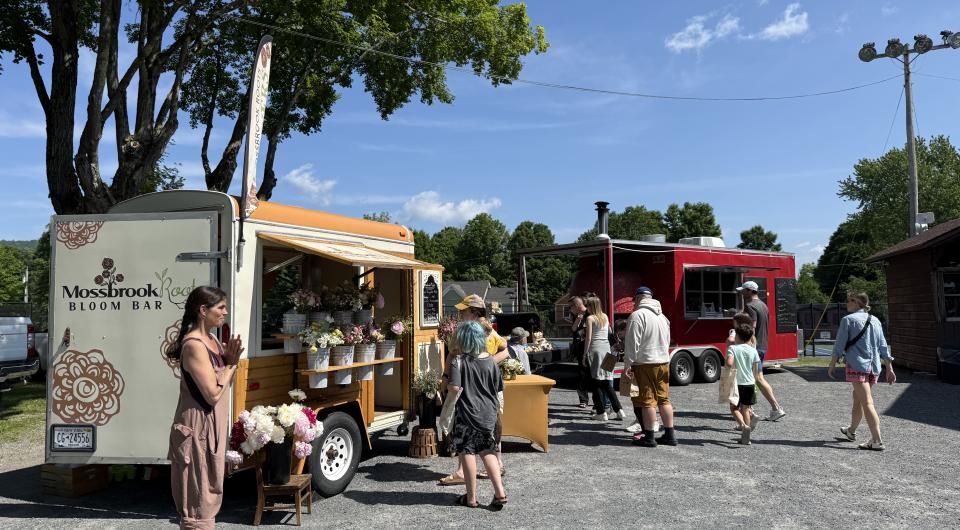  water bottles and kitchen utensils sit atop a yellow dresser in front of knotty pine walls