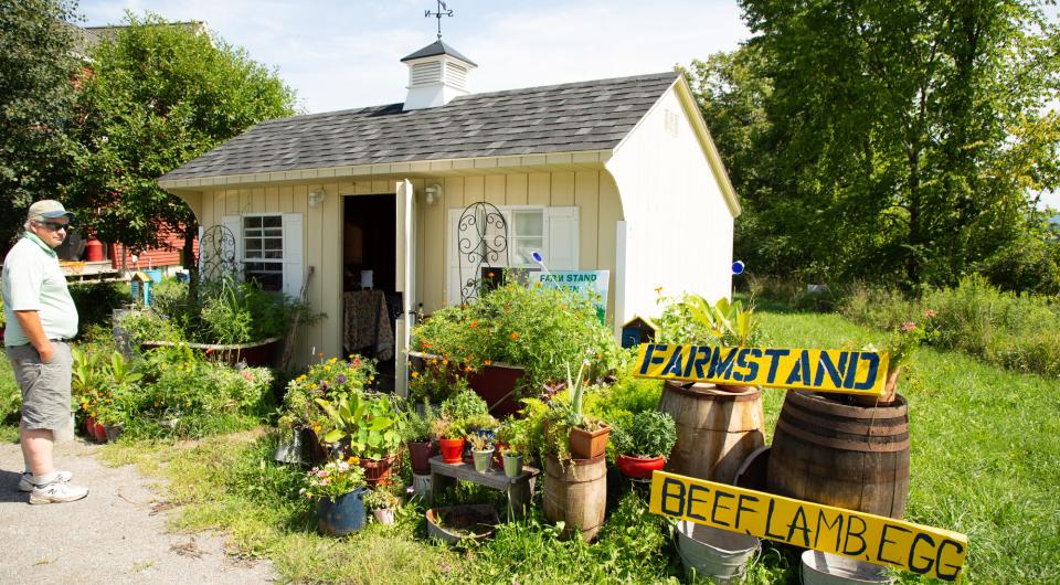 A farmstand in summer with fresh produce out front. 