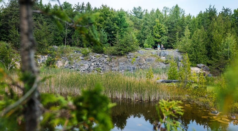 Two people on a bench above a quarry.