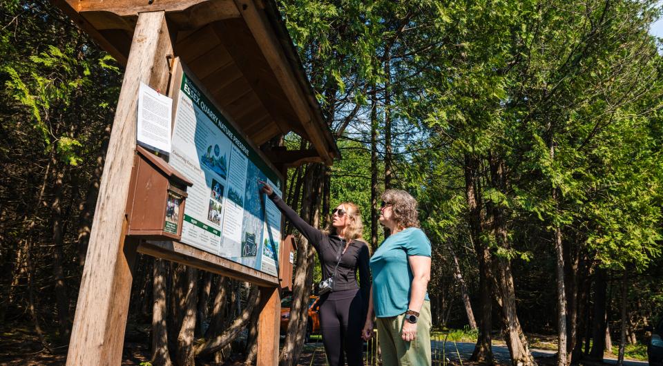 Two people at the Essex Quarry trailhead kiosk