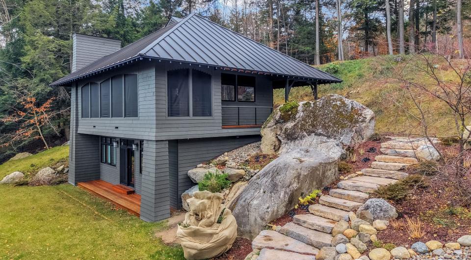A modern grey home with metal roof and tall