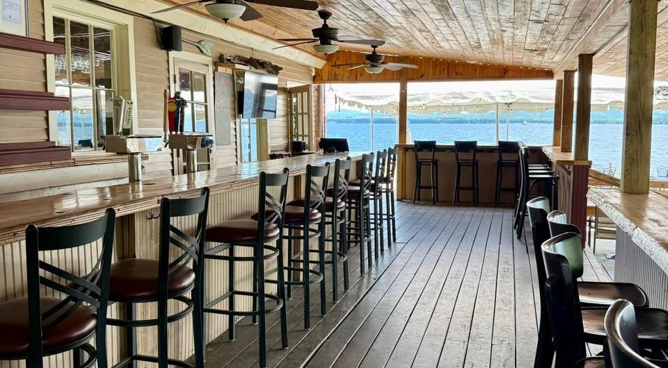 Looking down the bar on a covered porch at the open waters of Lake Champlain.