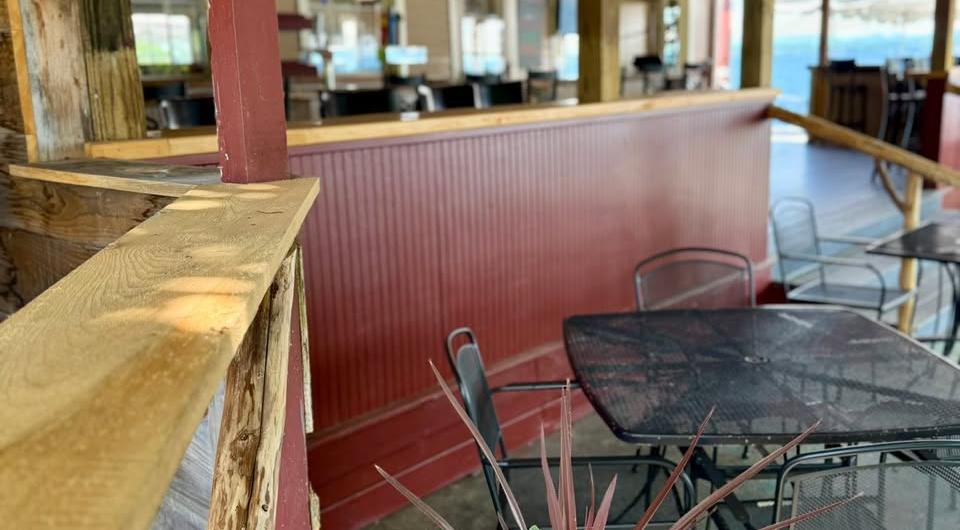 A long bar and seating area under a covered porch.