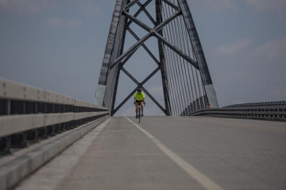 A cyclist crosses the Lake Champlain Bridge.