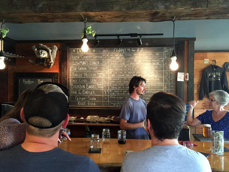 A bartender answers a question at a rustic bar.