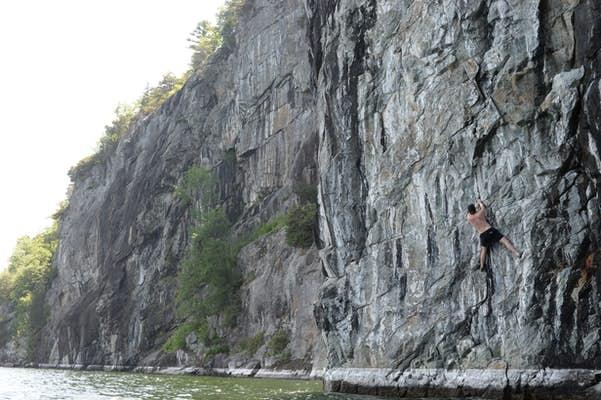 A man rock climbs the vertical face of the Palisades.