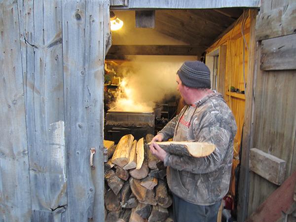 Kevin Sayre loads his arms up with fresh wood for the firebox.