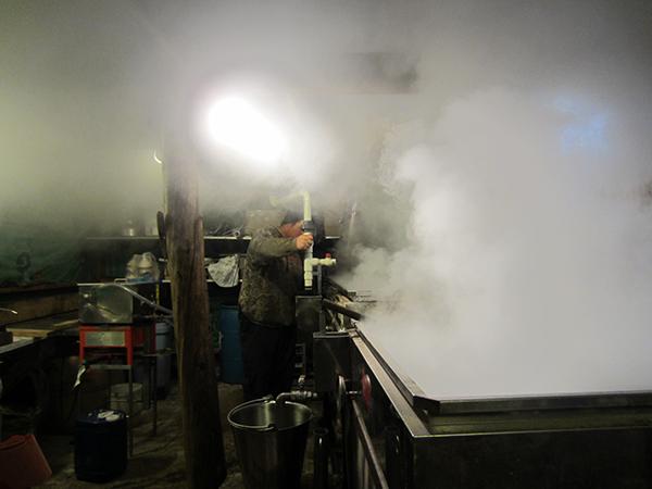 The interior of the sugar shack filled with steam.