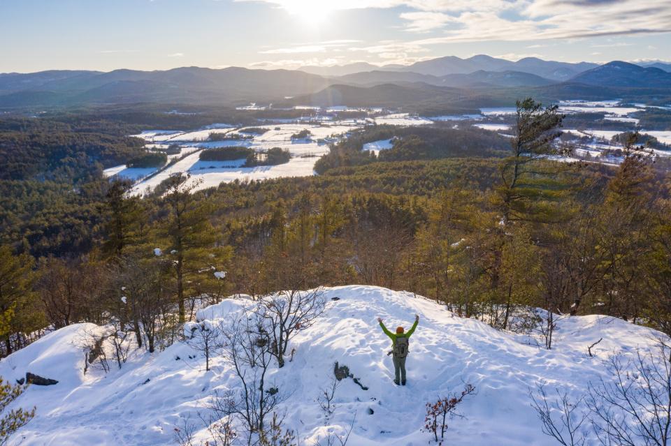 An aerial view of a person on a bald winter summit.