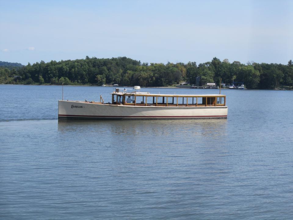 The tourboat Carillon on Lake Champlain with a tree-lined shore beyond.