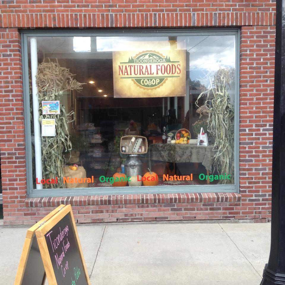 A large storefront window with a sign that reads "Ticonderoga Natural Foods"