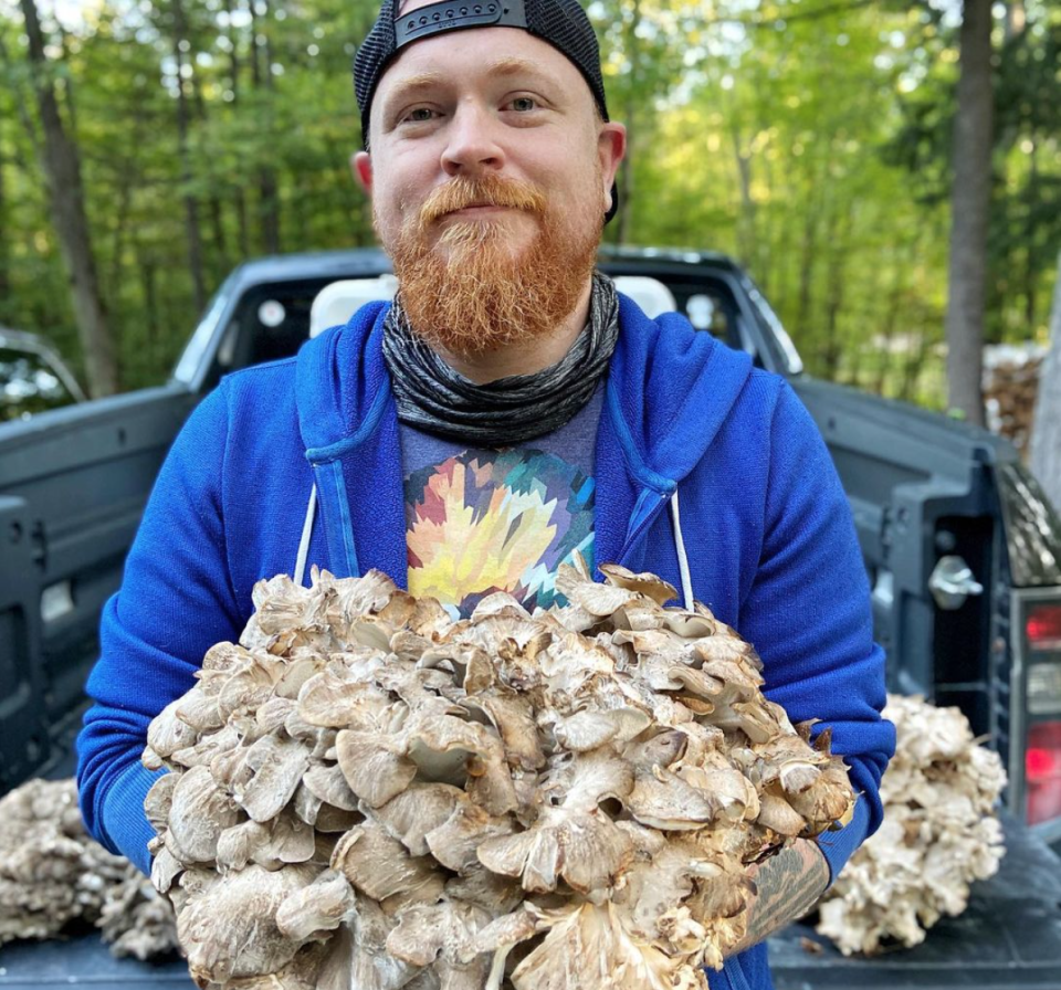Jordan Sauter stands in front of his truck holding mushrooms