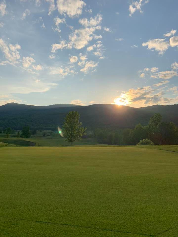 The sun sets behind the mountains seen from the Ticonderoga Golf Course