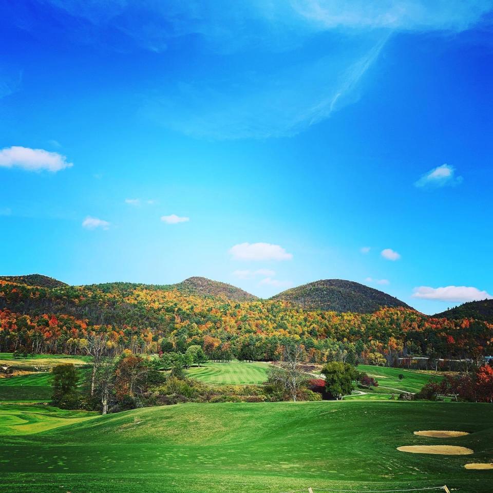 The trees along the mountain change colors as fall approaches at the Ticonderoga Golf Course