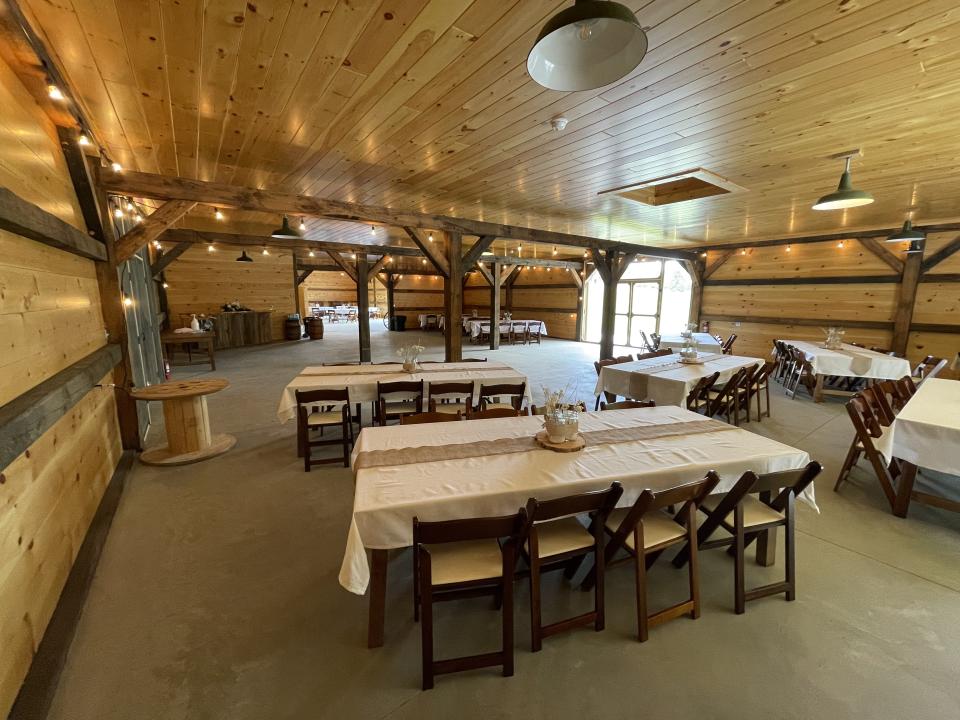 Inside the celebration barn at Edgemont Inn with tables with white linens and a rustic centerpiece.