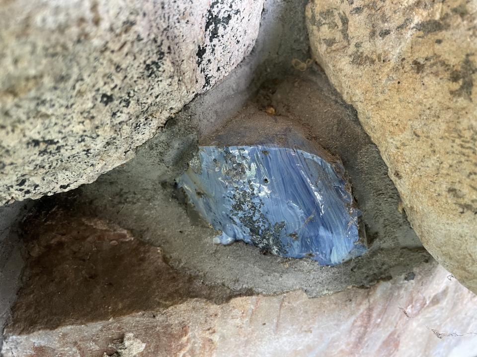 A bright blue piece of rock embedded in stonework.