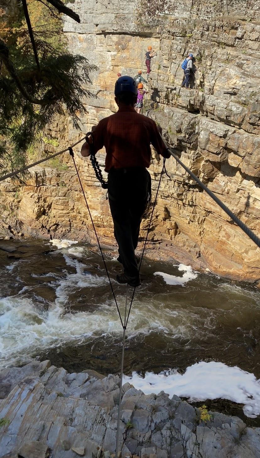 Man walks across cable bridge on Adventure Trail at Ausable Chasm