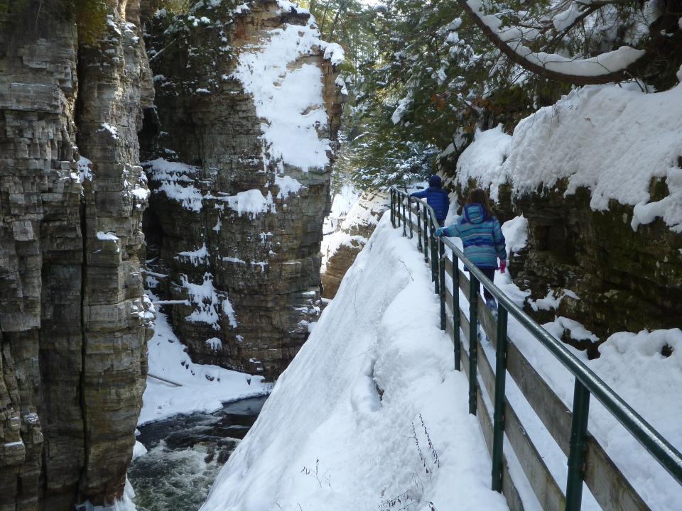 Two children snowshoe down the trail above the chasm