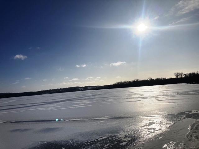 A view of a frozen, ice covered lake.