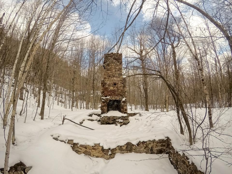 The stone chimney that remains of an old mountainside cabin.