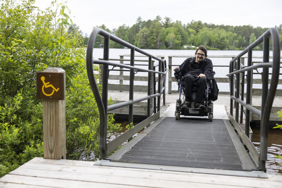 A person in a wheelchair moves up an accessible ramp