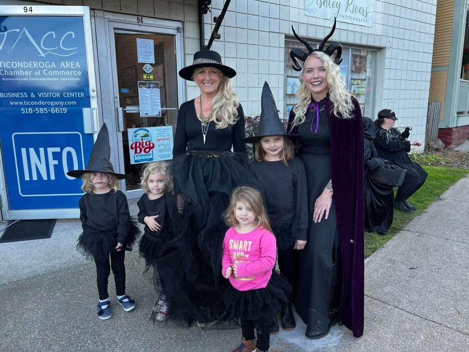 Women and small children dressed in black witches costumes.