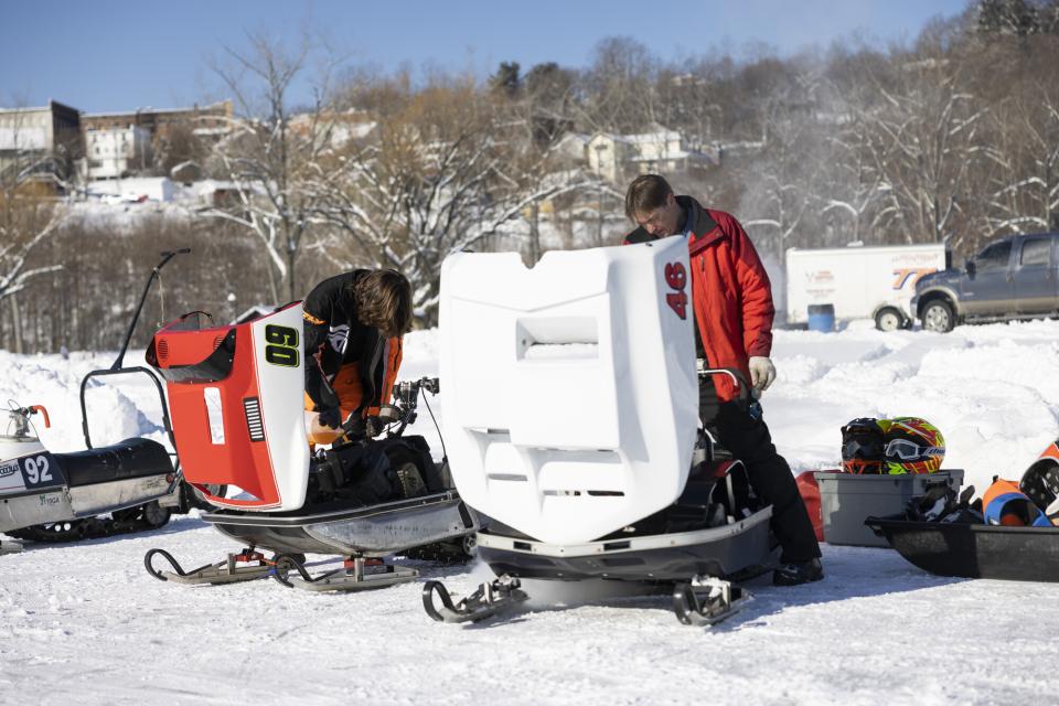 Racers inspecting their sleds