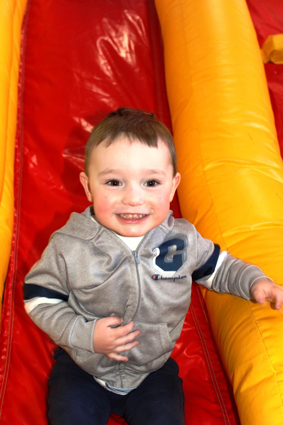 A child on a red and yellow inflatable slide