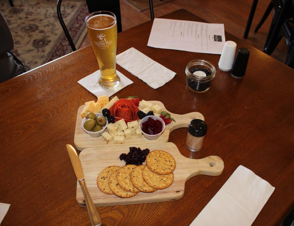 Two charcuterie boards on a table with beer
