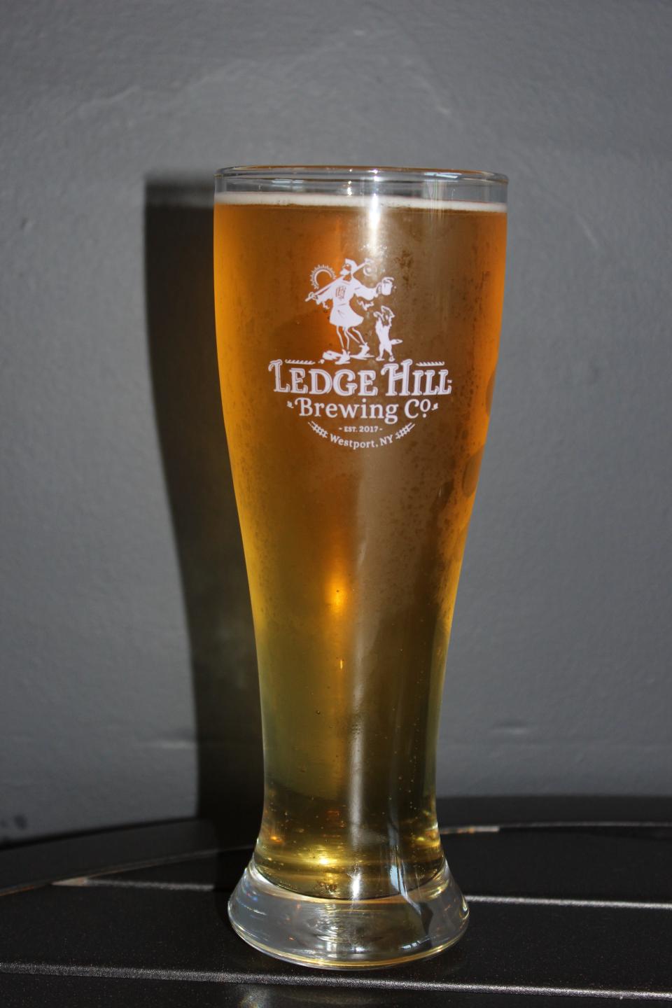 A tall, frosty glass of beer that reads "Ledge Hill Brewing Co." on it.