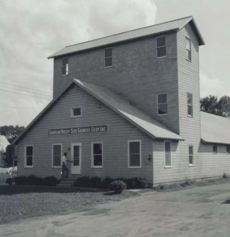 Old, black and white image of a three-story mill in Westport