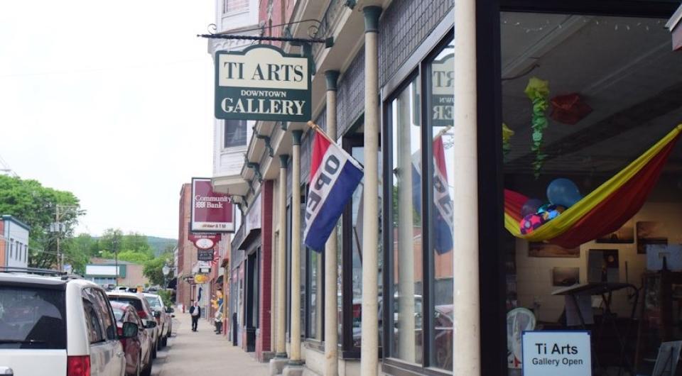 Ti Arts Gallery sign hanging over the sidewalk on Main Street.