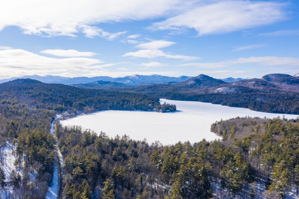 A scenic view of mountains and a frozen lake in winter.