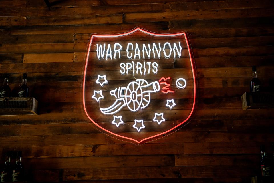 A lighted neon sign displays the War Cannon Spirits logo