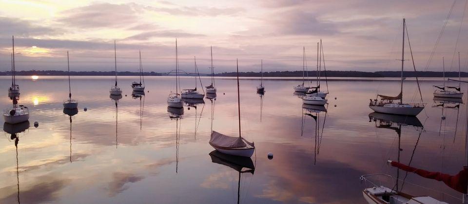 moored sailboats agains pink evening sky