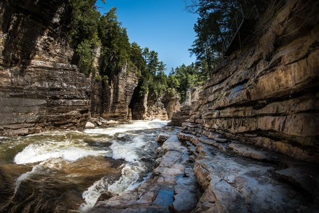 A view of the water rushing past with the towering walls of the gorge surrounding you