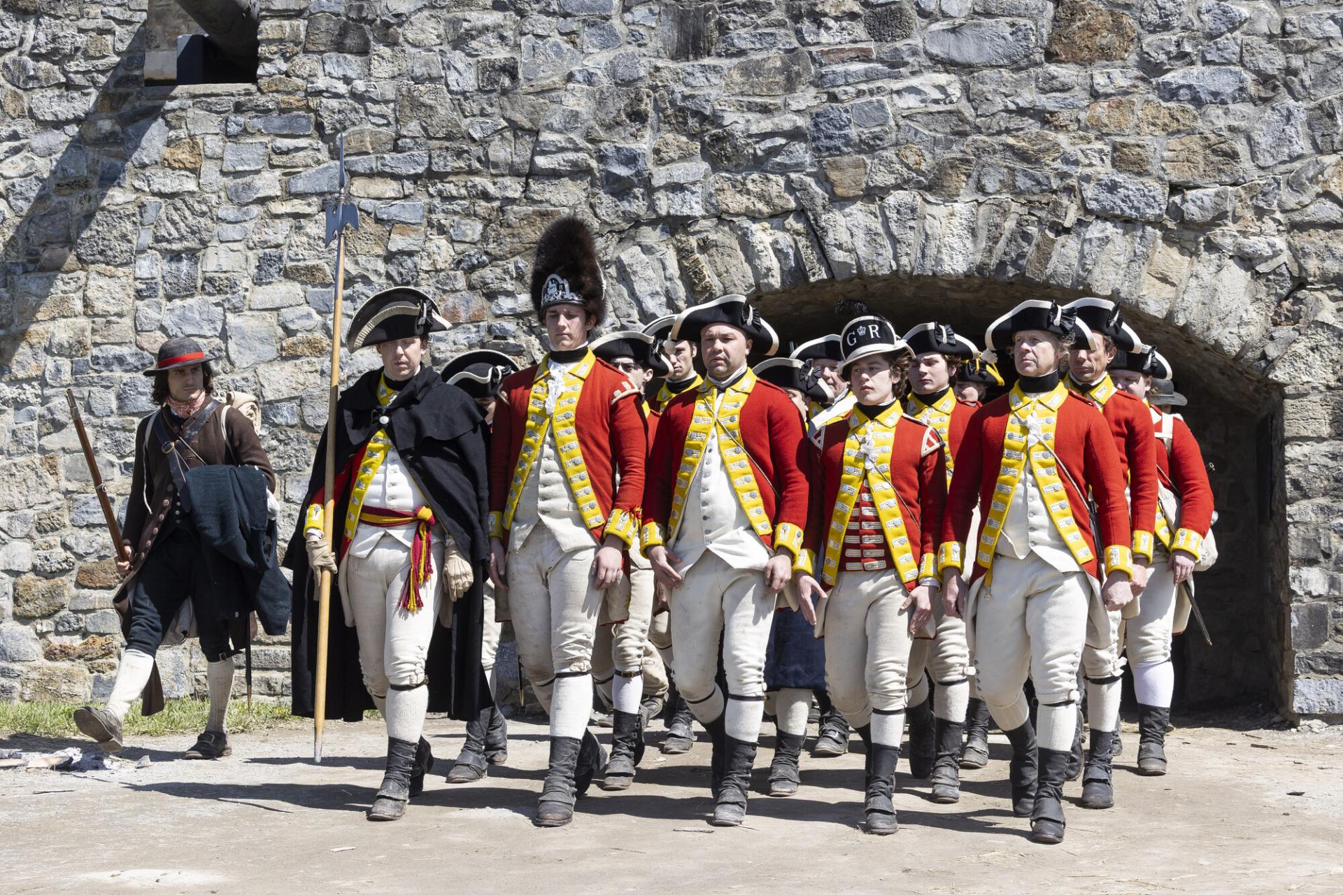A kid wearing the tall black furry hat of the redcoats