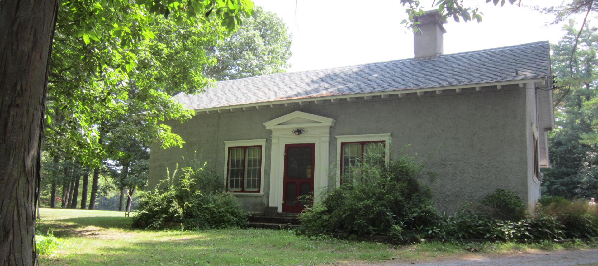 A small green structure with white trim.