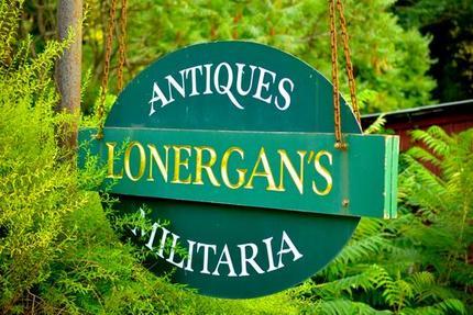 A green hanging sign reading Antiques Lonergan's Militaria