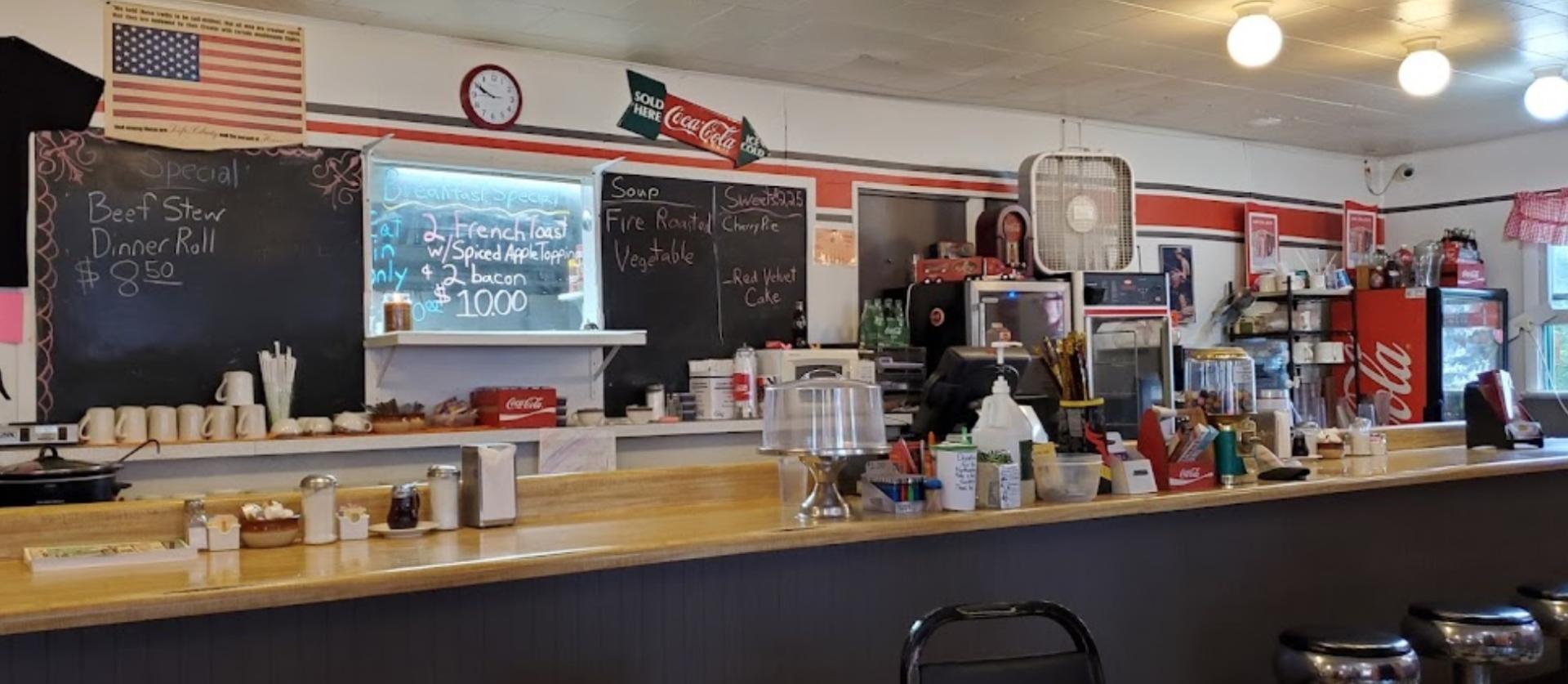 The diner bar with chalkboard with specials behind.