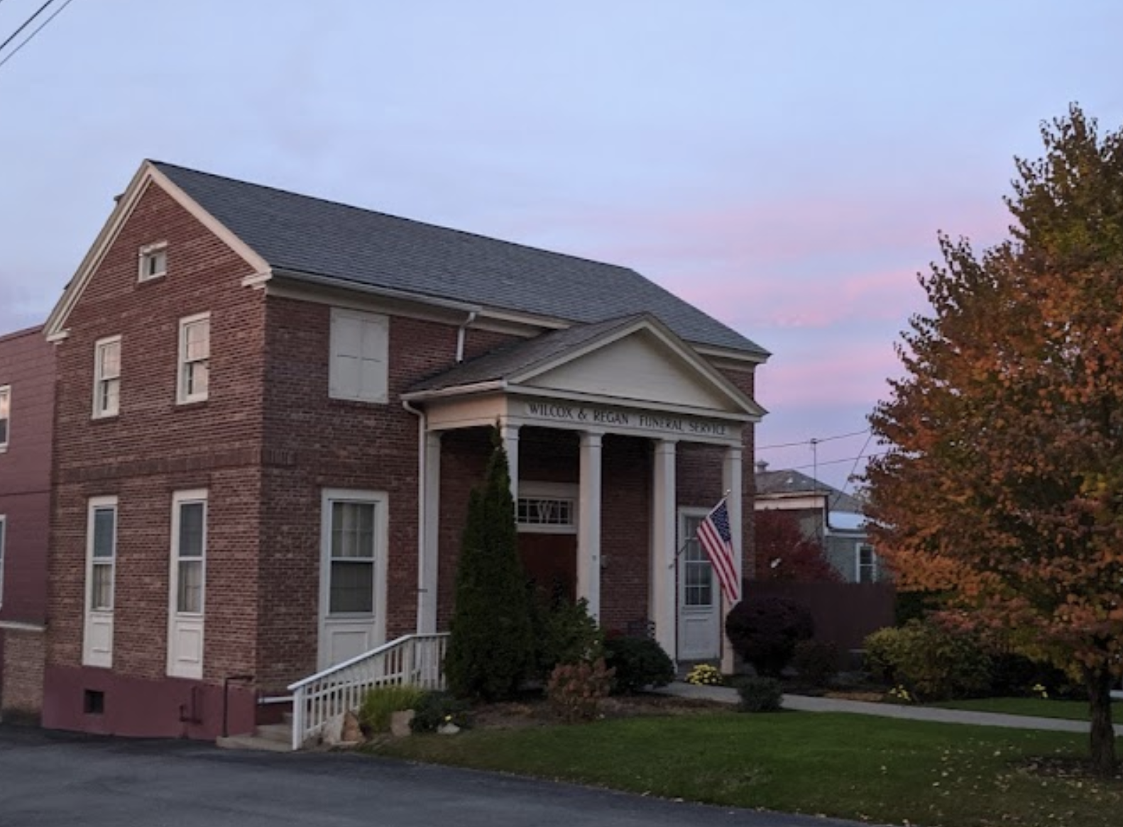 A large brick structure with white trim and large columns.