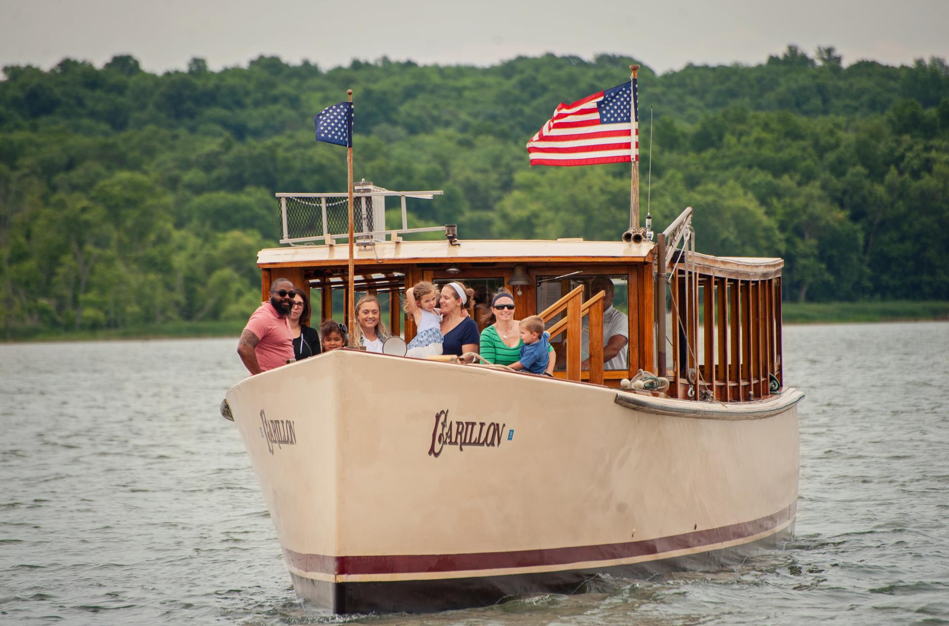 People stand on the bow of the Carillon during their cruise.