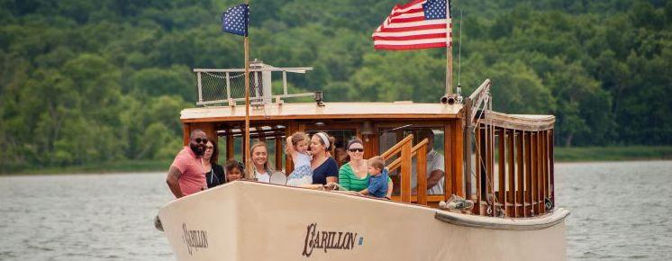 People stand on the bow of the Carillon during their cruise.