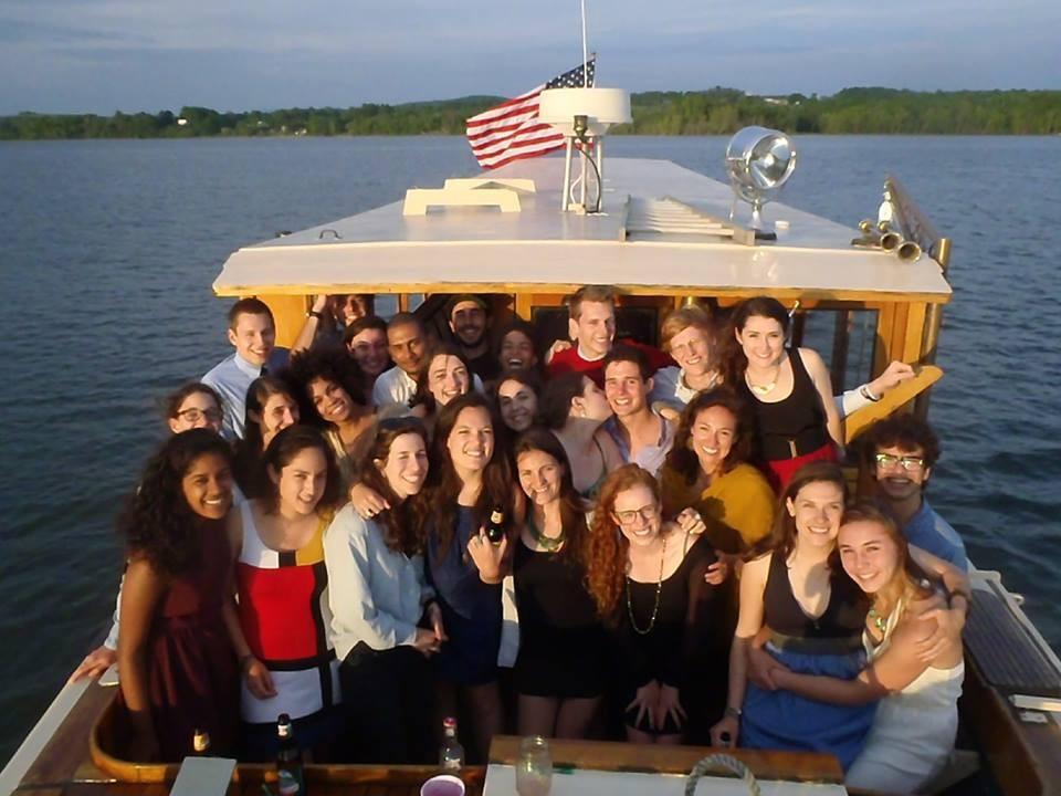 A group of nicely dressed young people stand together on the back of the Carillon